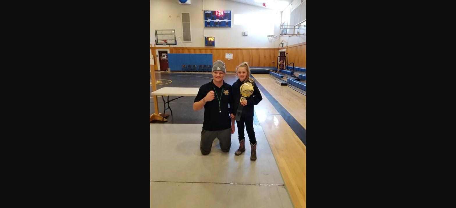 Coach and wrestler with a championship belt